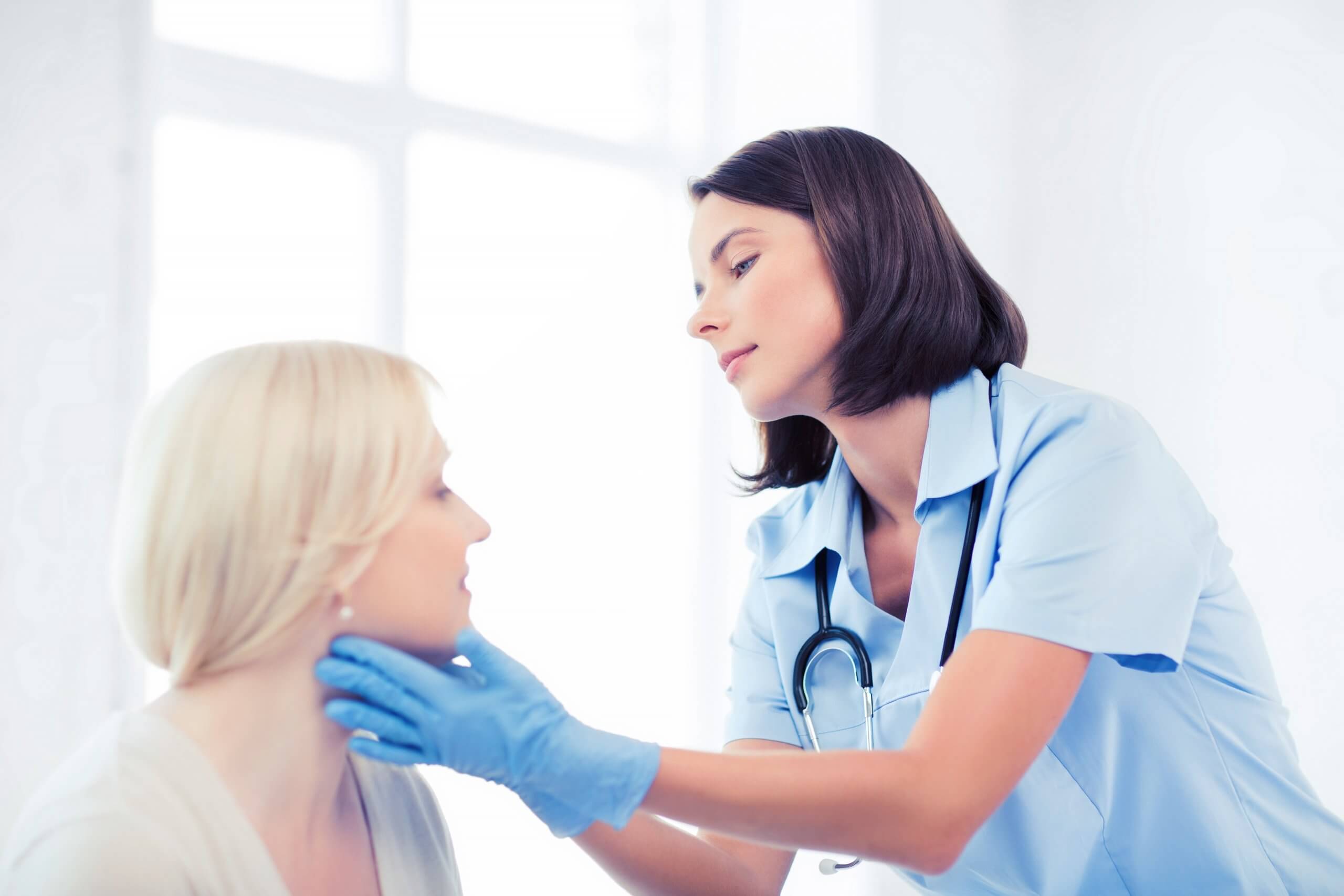 aesthetic nurse practitioner examining a woman's face