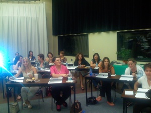 National Laser Institute students gather and watch a laser hair removal video in a classroom setting.