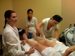 A National Laser Institute educator explains to students how a hair removal procedure is done.