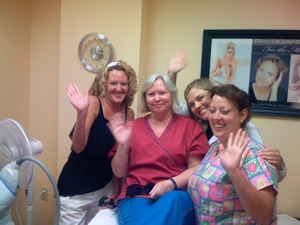 Students gather around a patient who completed a laser hair removal treatment at a National Laser Institute facility.
