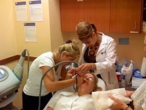 A student performs a laser hair removal procedure on a patient while her National Laser Institute instructor observes her.