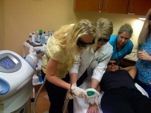 While a student works on a laser hair removal patient, a National Laser Institute teacher explains to students how it is done