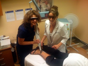 A female National Laser Institute student performs a hair removal procedure while her teach observes her.