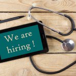 An image of a stethoscope with a sign saying we are hiring aesthethic nurses in the Dallas Forth Worth area.