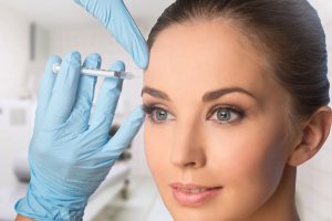 A National Laser Institute student, under supervision, gives a Botox injection to a female patient.